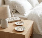 Porcelain jewelry tray and ring dish displayed on a dresser for organizing small accessories.