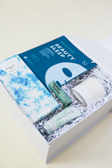 All is Calm Holiday Gift Box, blue gift box, patchology beauty sleep mask, calm lavender candle, compartres marshmallow crips chocolate bar, poppy pout sweet mint lip balm, heritage hand cream - white gardenia, Confete gifts and party boxes