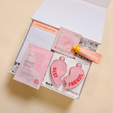 Galentine’s Day BFF gift box featuring heart flask, self care sheet mask, rose eye gels, happy hour notepad, and champagne-scented lotion.