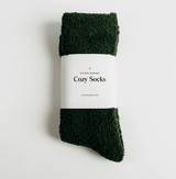 Green cozy socks with a white label on a light gray background