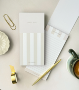 Slim To Do List Notepad with striped cover by Aim Studio Co. displayed on a desk.