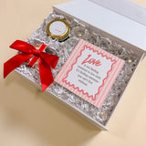 Luxury Valentine’s Day gift box for couples including acrylic picture frame with love quote, Be Mine candle, and Maeve chocolate bon bons.