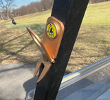 Golf accessory featuring the Beaver Tail Golf Club Alfred cigar holder with a cigar securely positioned above the turf.