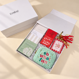 Oh What Fun Christmas gift box with a notebook, bath bomb, artisan chocolate, photo frame, eye gels, and cozy pouch.