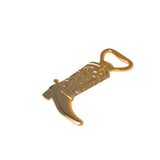 Angled view of gold western boot bottle opener with engraved cowboy boot details on beige background.
