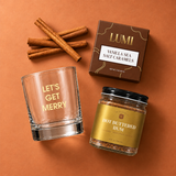 Mini Holiday Spirit products styled on a copper backdrop with a rocks glass, cocktail mix and caramels