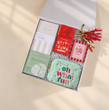 Bright Christmas care package for her filled with cozy, festive, and relaxing gifts in cheerful red, pink, and mint colors.
