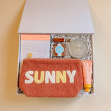 Summer Fun gift box with SUNNY teddy pouch, peach bellini candy, prosecco candle, lotion, and notepad