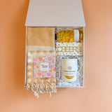 Luxury housewarming gift box with kitchen towel, ceramic mug, room spray, and acrylic picture frame
