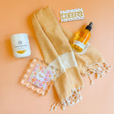 Flat lay of welcome home gift box with acrylic photo frame, cheers bottle opener, and home essentials
