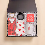 Be Mine Valentine’s Day luxury gift box with heart socks, Be Mine soy candle, red wine Compartés chocolate, ring tray, bath bomb, and love you more coffee mug.