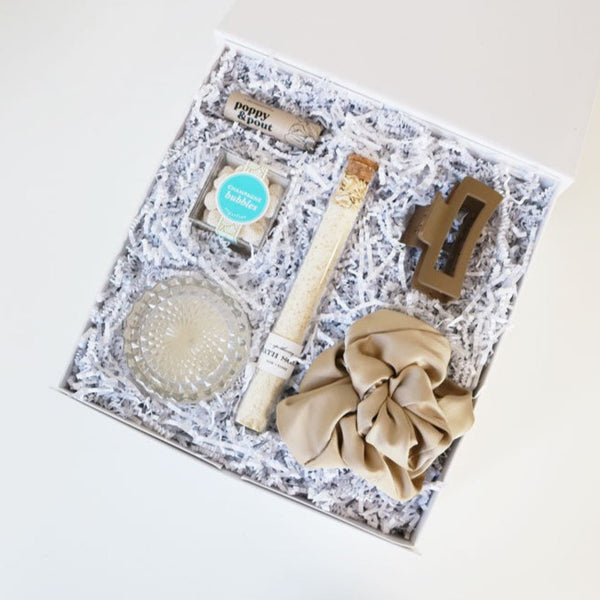 Indulge in the tranquility of our Island Time Gift Box – a curated escape with coconut lip balm, prosecco candle, silk scrunchie, caramel claw clip, oatmeal bath salt, and champagne candy. 