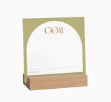 Goal Setting Cards with wooden holder by Aim Studio Co. displayed on a desk workspace.