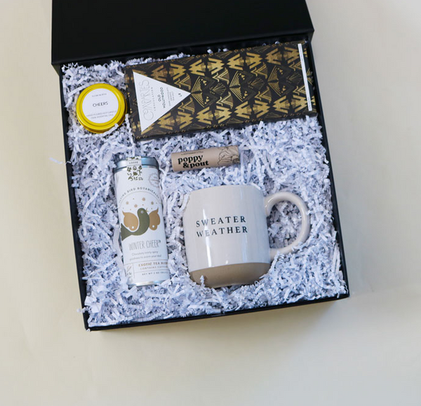 https://confetepartybox.com/cdn/shop/files/Sugar-and-Spice-Holiday-Gift-Box_-winter-cheer-tea-gift-box_-sweater-weather-coffee-mug_-poppy-pout-lip-balm_-cheer-candle_-holiday-gift-box_-white-elephant_-confete-party---3copy_600x.png?v=1696912955