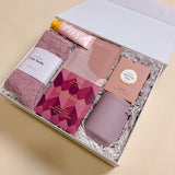 Wine Down relaxation gift box for women including wine tumbler, gourmet chocolate, rose candy gummies, champagne hour lotion, and soft cozy socks.