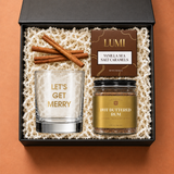 Mini Holiday Spirit gift box with a festive rocks glass, hot buttered rum mix, caramels and cinnamon sticks
