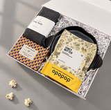 Movie lover gift box with Fancy Butter popcorn, Movie Buff Trivia, cozy socks, chocolates and a glass candle.


