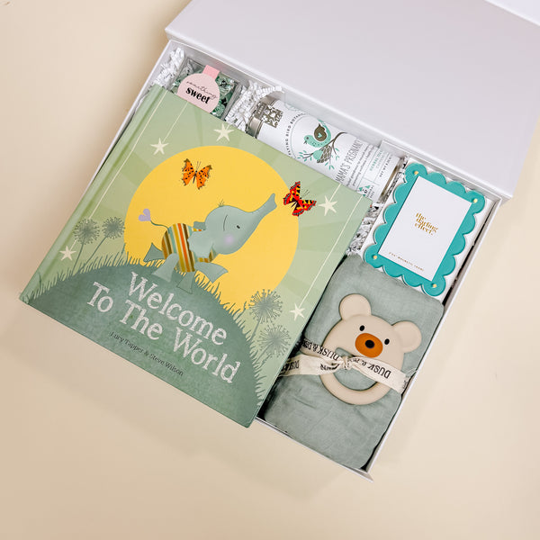 Angled view highlighting the swaddle, teether, and luxe packaging of the Confete New Baby Gift Box.
