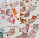 Two portable wine tumblers filled with red wine on a table — durable and elegant outdoor drinkware.