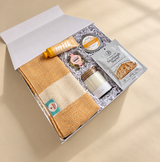 Sourdough baking gift box featuring starter, bread dip seasoning, woven tea towel and thoughtful self-care treats.